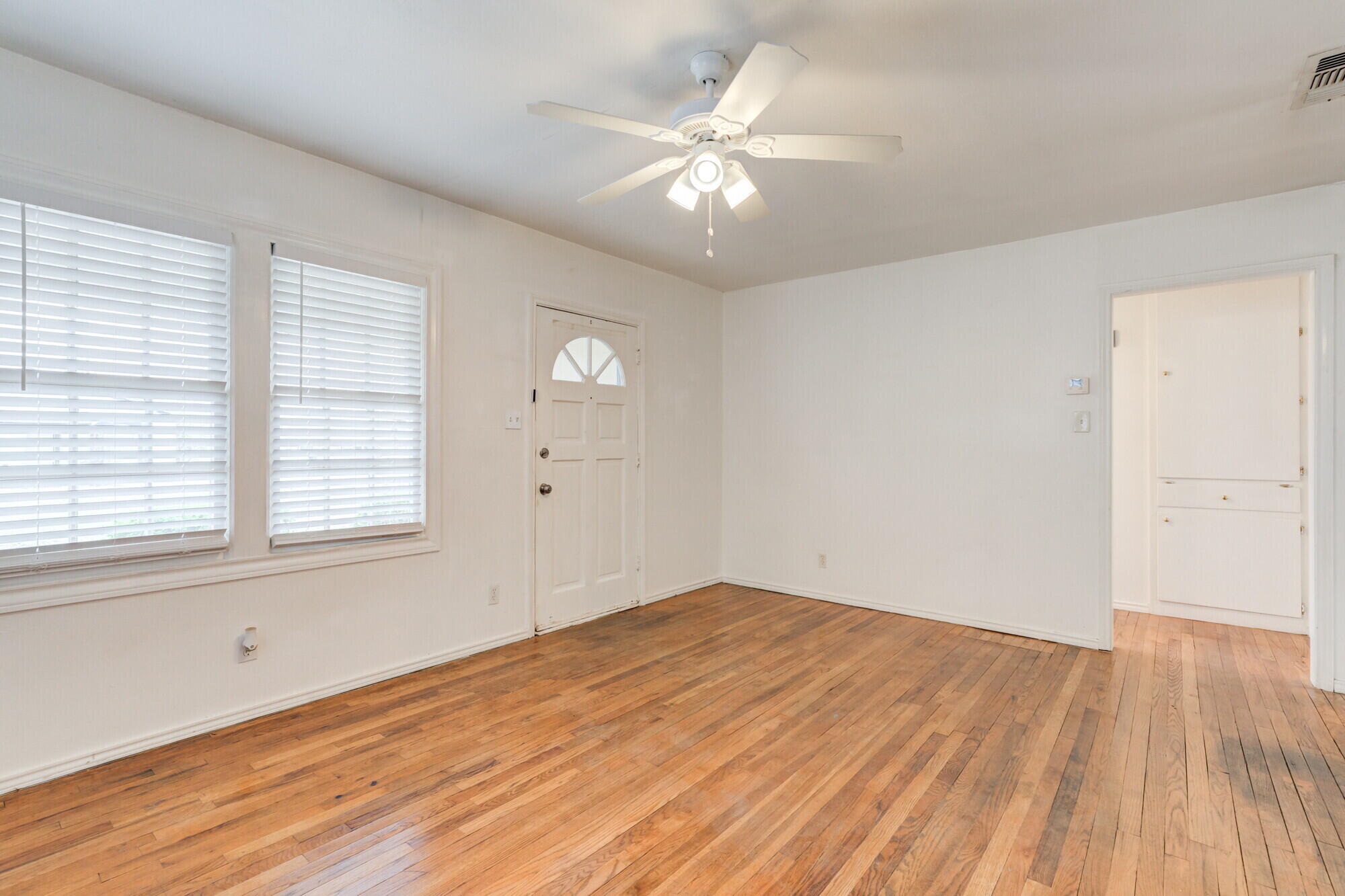 2701 36th Street Lubbock, TX 79413 - Photo 6 of 23 an empty room with wooden floor and windows