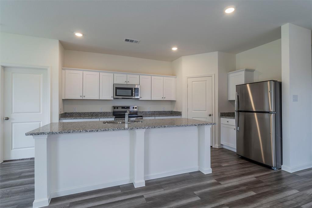 1838 Mccree Street Forney, TX 75126 - Photo 5 of 33 a kitchen with stainless steel appliances granite countertop a refrigerator a sink and a stove
