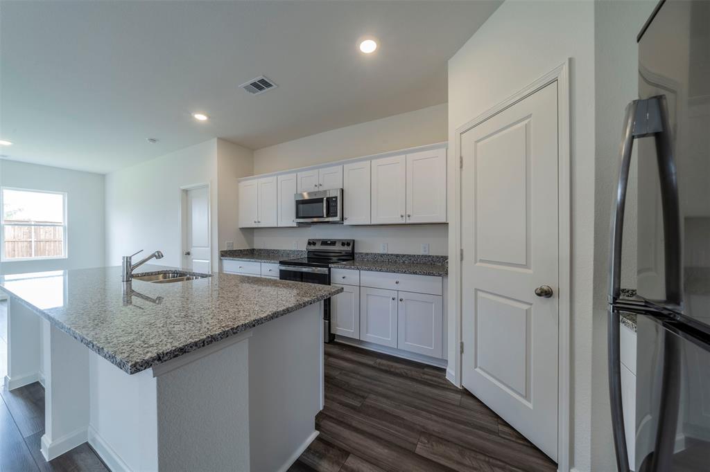 1838 Mccree Street Forney, TX 75126 - Photo 6 of 33 a kitchen with stainless steel appliances granite countertop a sink stove and refrigerator