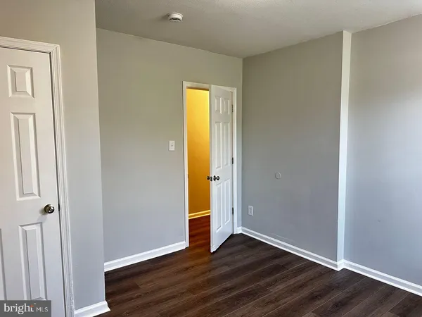 an empty room with wooden floor and closet