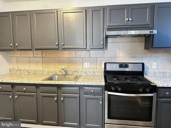 a kitchen with granite countertop cabinets and white stove