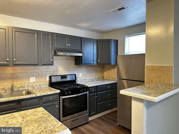a kitchen with a sink and a stove top oven