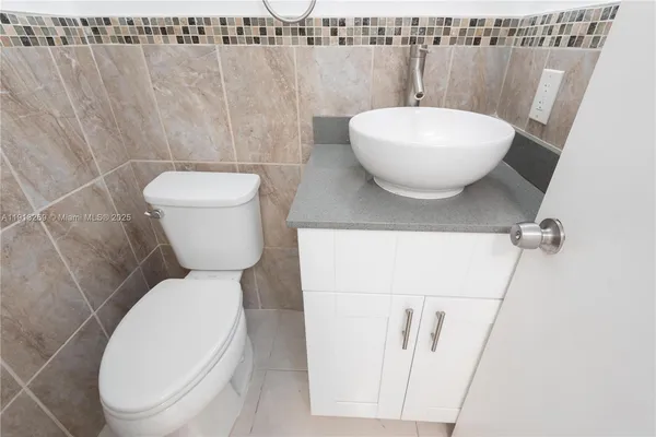 a white toilet sitting next to a white sink