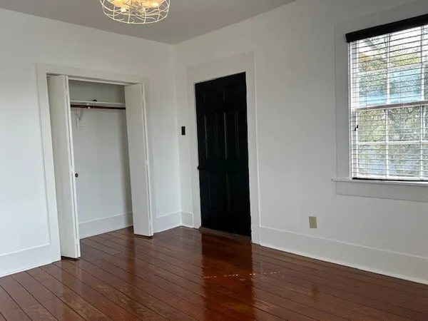 a view of an empty room with wooden floor