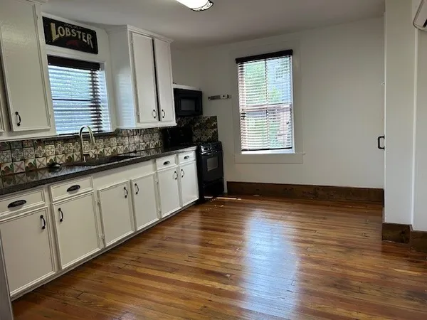 a view of a kitchen with wooden floor and staircase