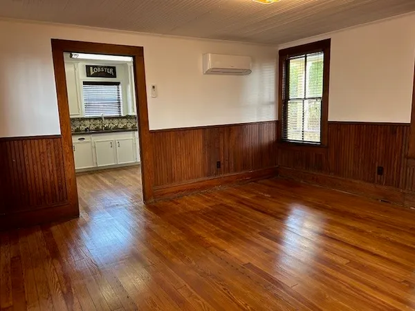 an empty room with wooden floor and a window