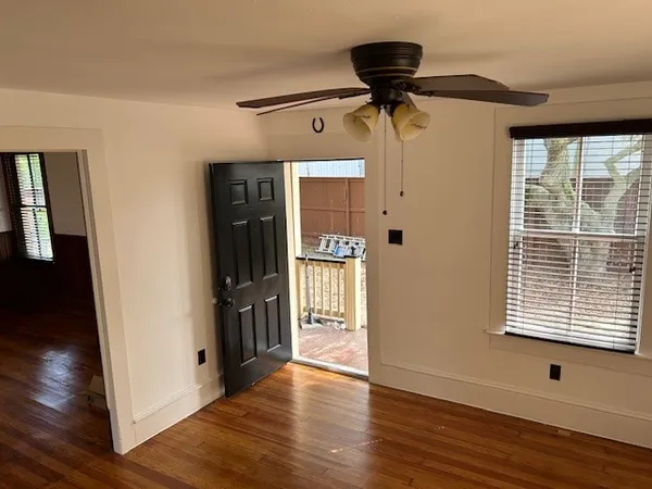 a view of a hallway with wooden floor and windows
