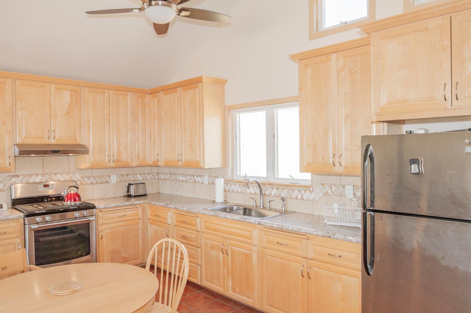 44981 Todd Eymann Road Dunlap, CA 93621 - Photo 12 of 95 a kitchen with a refrigerator a sink and white cabinets
