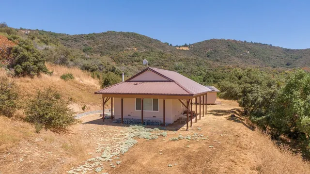 a view of a lush green field with mountains in the background