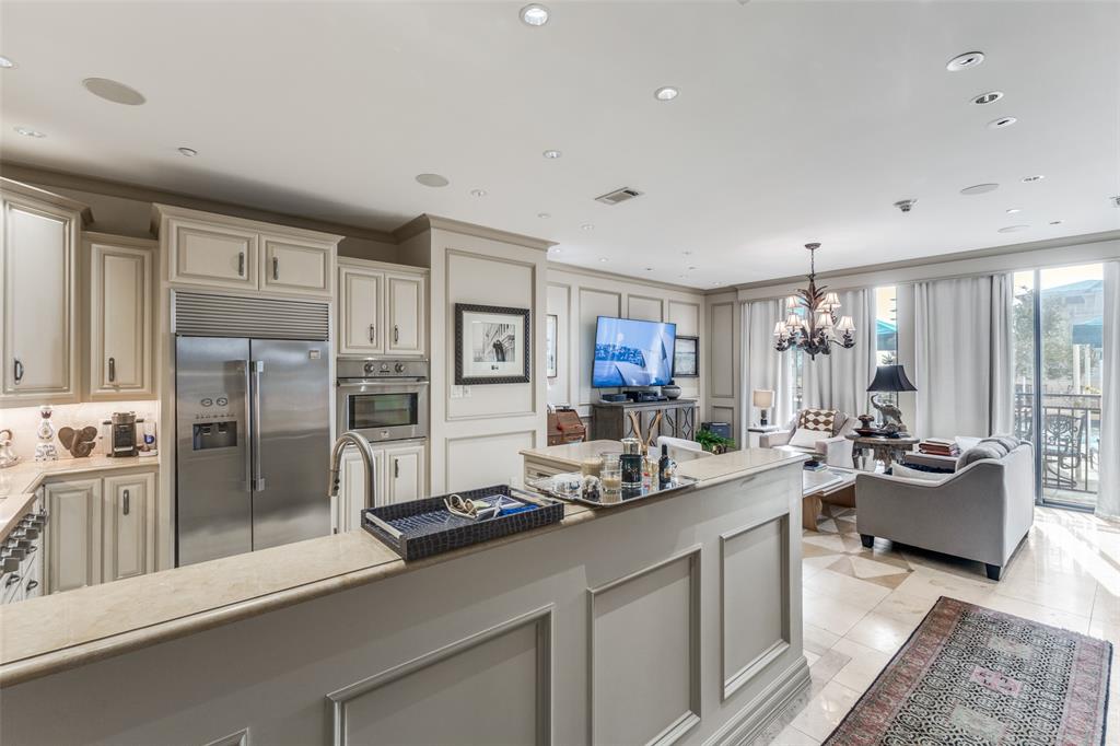 5909 Luther Lane, Unit 707 Dallas, TX 75225 - Photo 12 of 14 a room with stainless steel appliances kitchen island granite countertop a refrigerator and couches