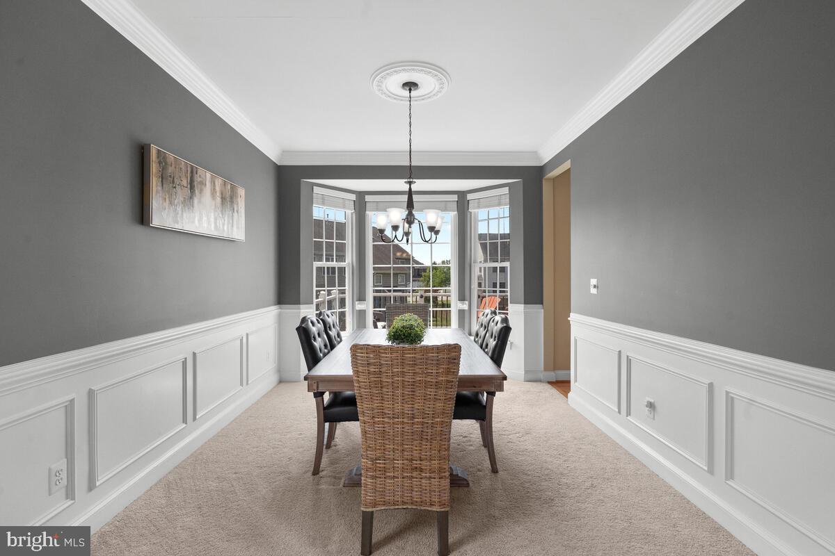42819 Conquest Circle Ashburn, VA 20148 - Photo 16 of 55 a dining room with furniture a chandelier and wooden floor