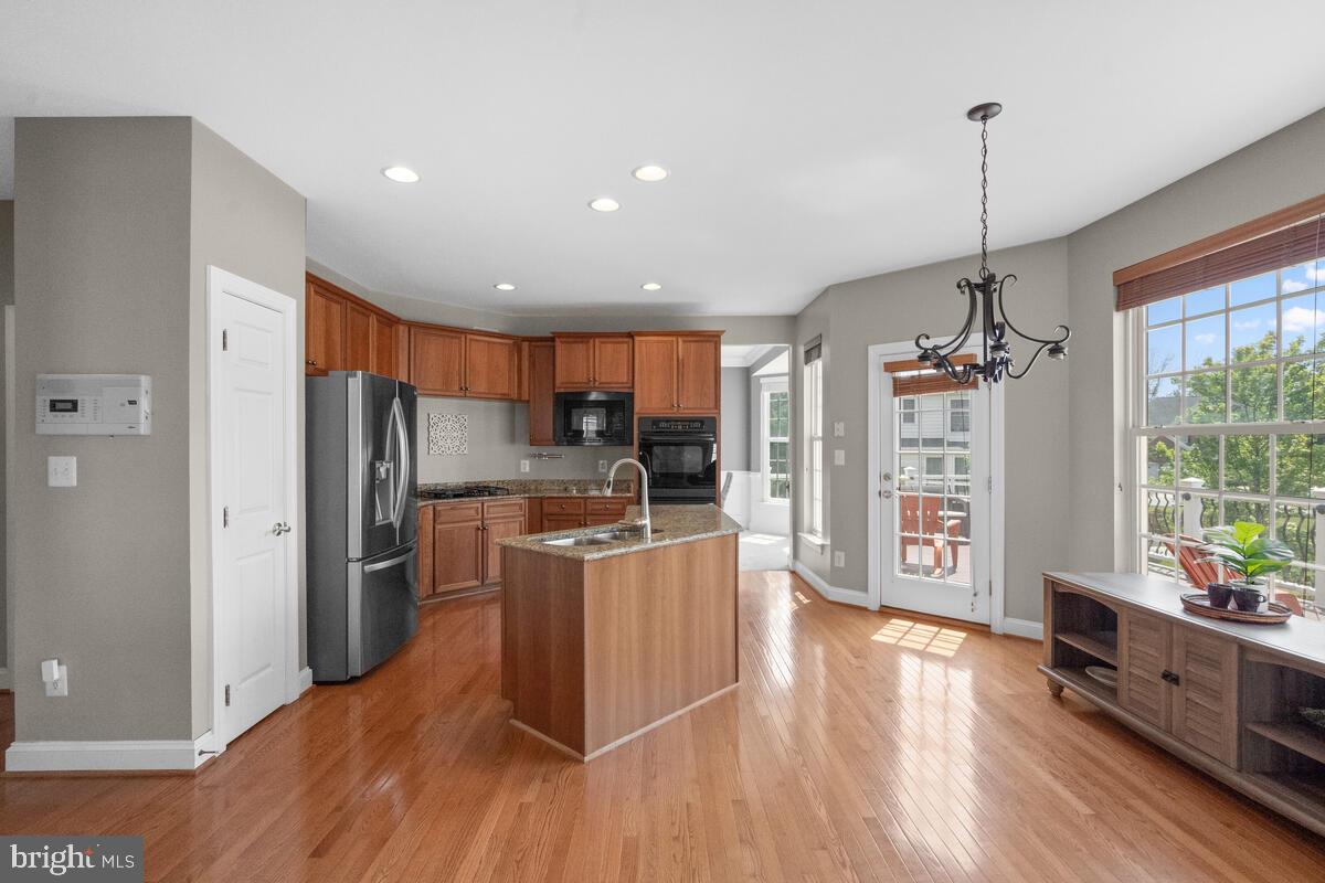 42819 Conquest Circle Ashburn, VA 20148 - Photo 17 of 55 a kitchen with stainless steel appliances granite countertop a refrigerator a stove top oven and a wooden floor