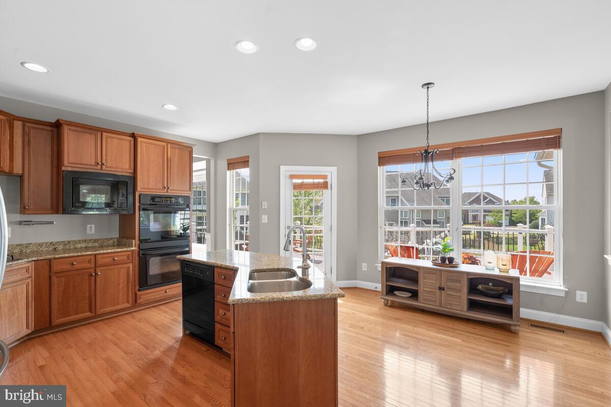 42819 Conquest Circle Ashburn, VA 20148 - Photo 18 of 55 a view of a kitchen with kitchen island granite countertop a sink and counter top space