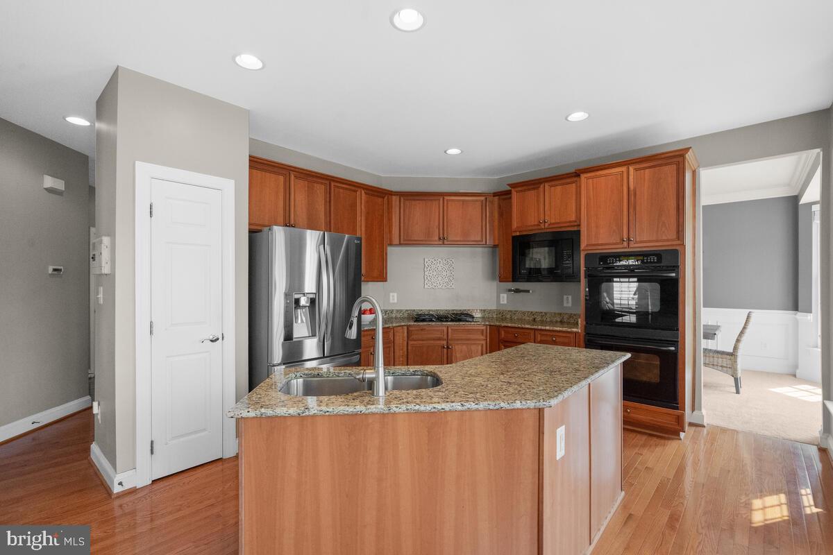 42819 Conquest Circle Ashburn, VA 20148 - Photo 21 of 55 a kitchen with stainless steel appliances granite countertop a refrigerator a sink dishwasher a stove and a refrigerator with wooden floor