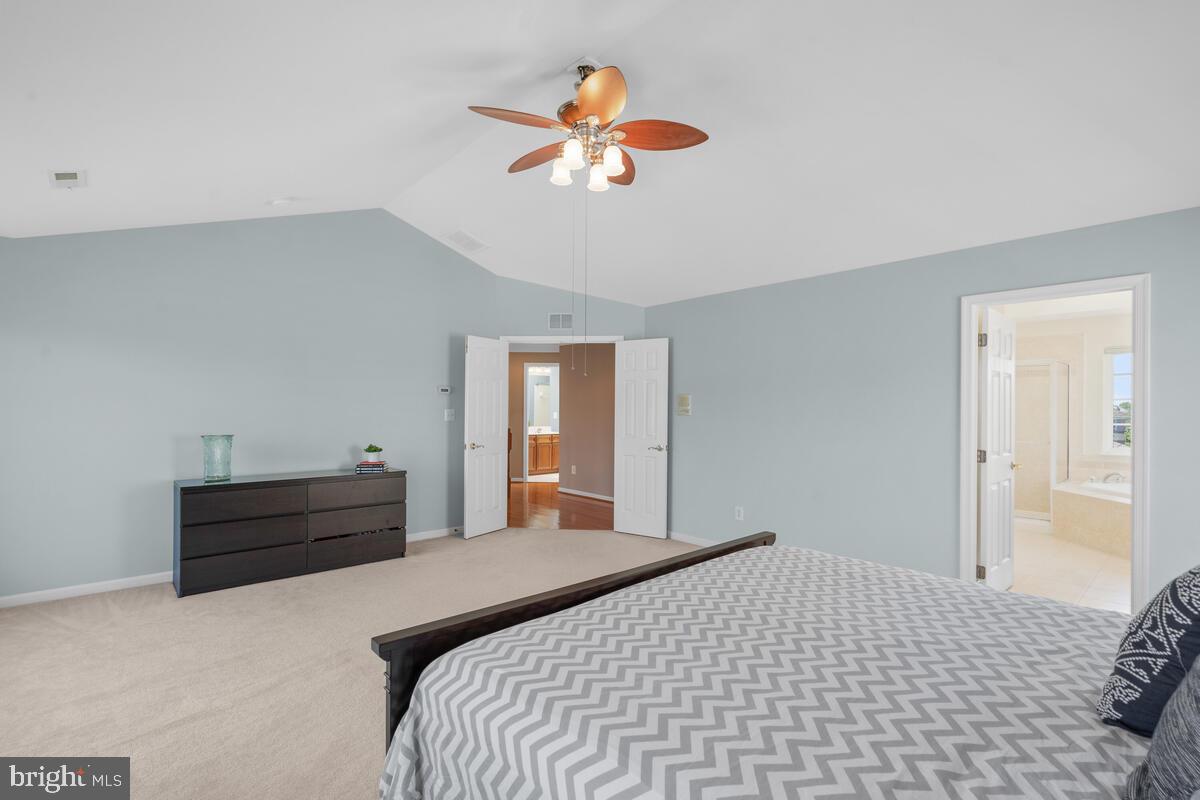 42819 Conquest Circle Ashburn, VA 20148 - Photo 28 of 55 a bedroom with a bed and a chandelier