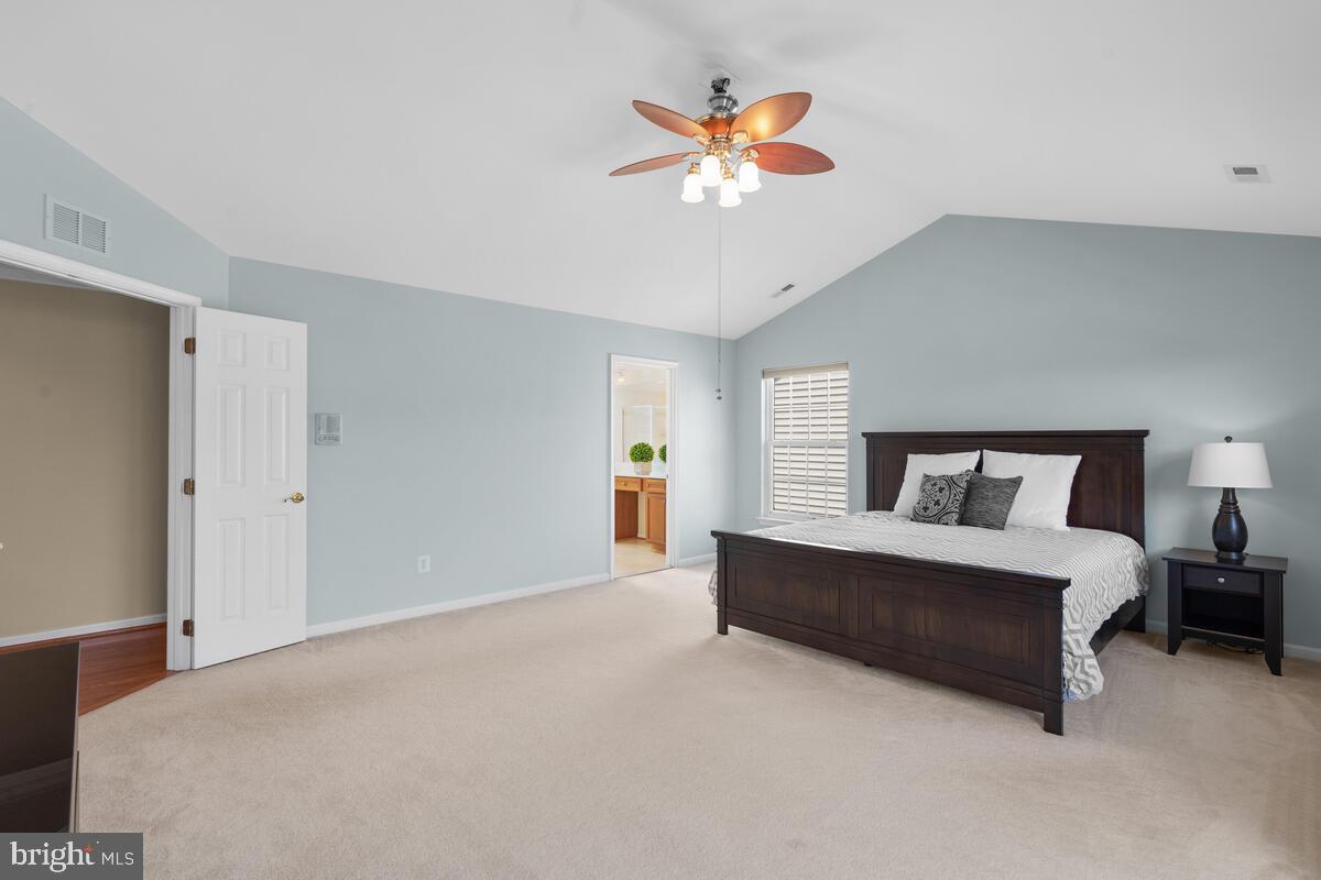 42819 Conquest Circle Ashburn, VA 20148 - Photo 29 of 55 a spacious bedroom with a bed and a chandelier