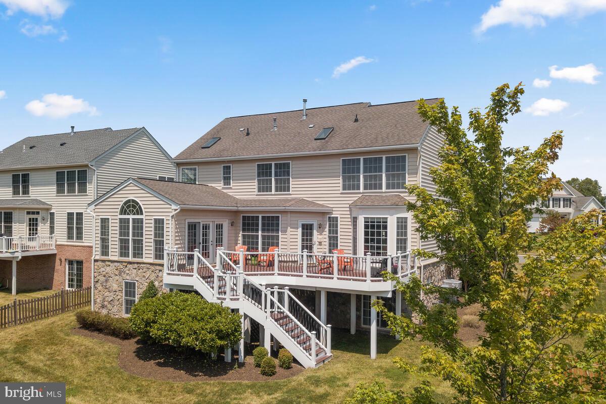 42819 Conquest Circle Ashburn, VA 20148 - Photo 46 of 55 a view of a white house with large windows and a yard