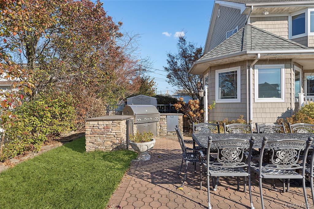4 Quebec Road Island Park, NY 11558 - Photo 16 of 24 a view of a patio with table and chairs and potted plants