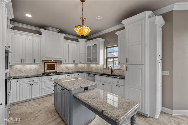 a kitchen with stainless steel appliances granite countertop a sink a stove and a refrigerator