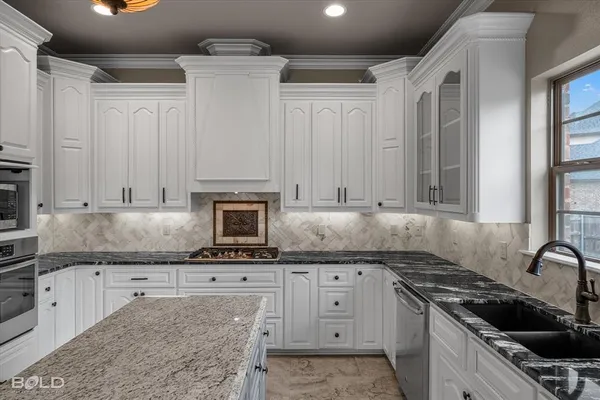 a kitchen with granite countertop a stove sink and cabinets