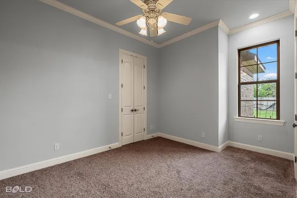 an empty room with windows and ceiling fan
