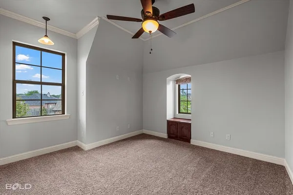 an empty room with chandelier fan and windows
