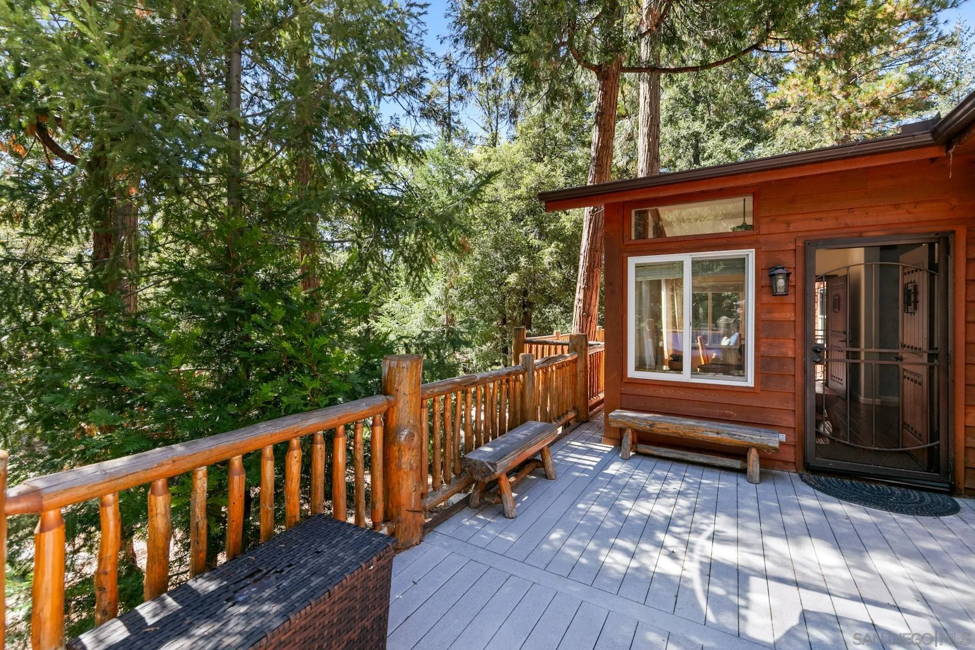 24655 Upper Rim Rock Road Idyllwild, CA 92549 - Photo 18 of 48 a view of a house with a small deck and a floor to ceiling window with wooden floor