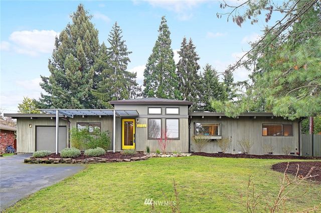 a front view of a house with a garden and trees