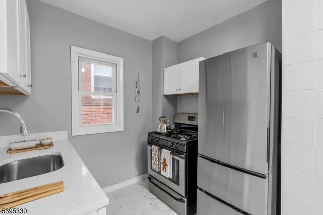 a kitchen with granite countertop a sink cabinets and stainless steel appliances