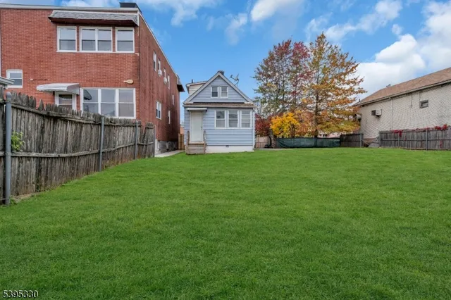 a view of a yard in front of a house with large trees