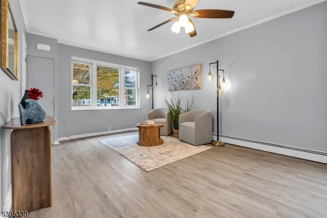 a view of a livingroom with a potted plant a ceiling fan and a window
