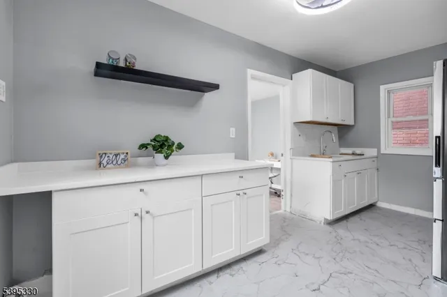 a kitchen with white cabinets and white appliances