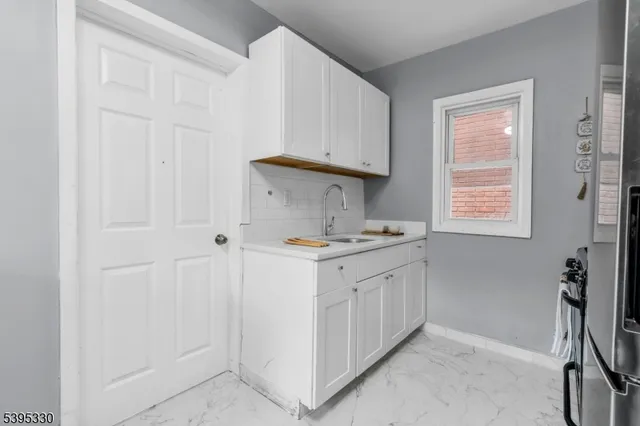 a kitchen with kitchen island granite countertop a sink and a stove