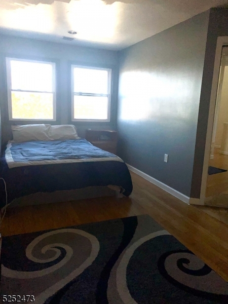 14 Jaques Street, Unit 24 Elizabeth, NJ 07201 - Photo 9 of 17 a bed sitting in a bedroom next to a window