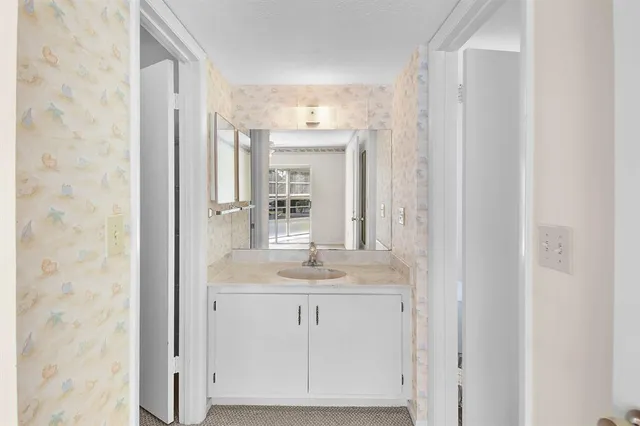 a bathroom with a granite countertop shower and a sink