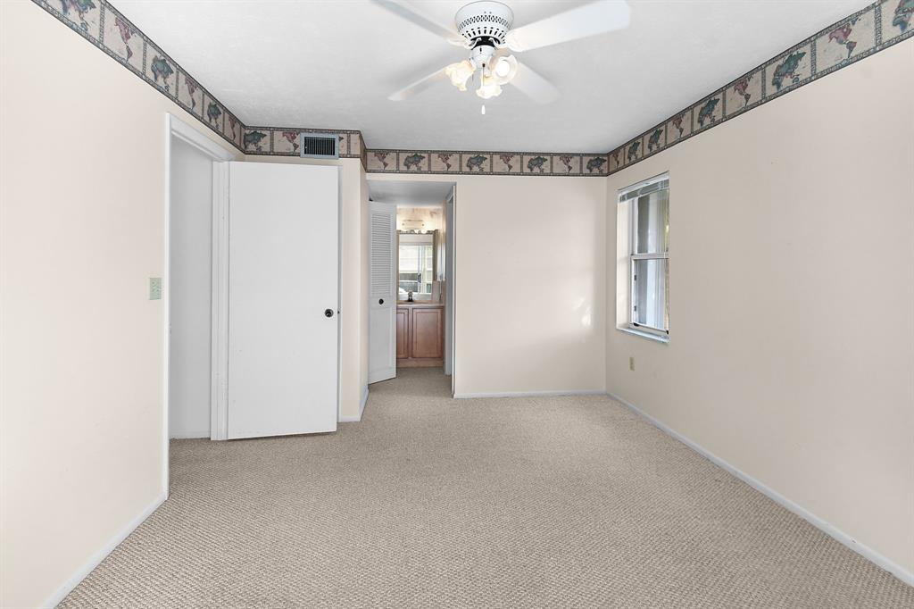 3254 Southeast Aster Lane, Unit J240 Stuart, FL 34994 - Photo 18 of 39 an empty room with chandelier fan and windows
