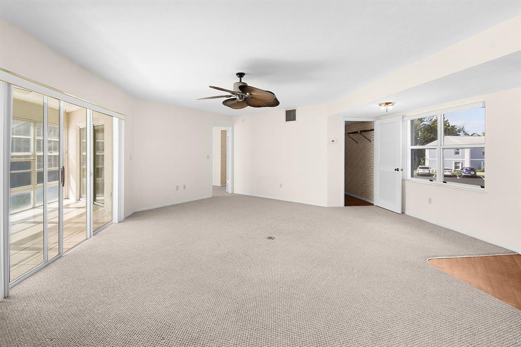 3254 Southeast Aster Lane, Unit J240 Stuart, FL 34994 - Photo 7 of 39 an empty room with windows and ceiling fan