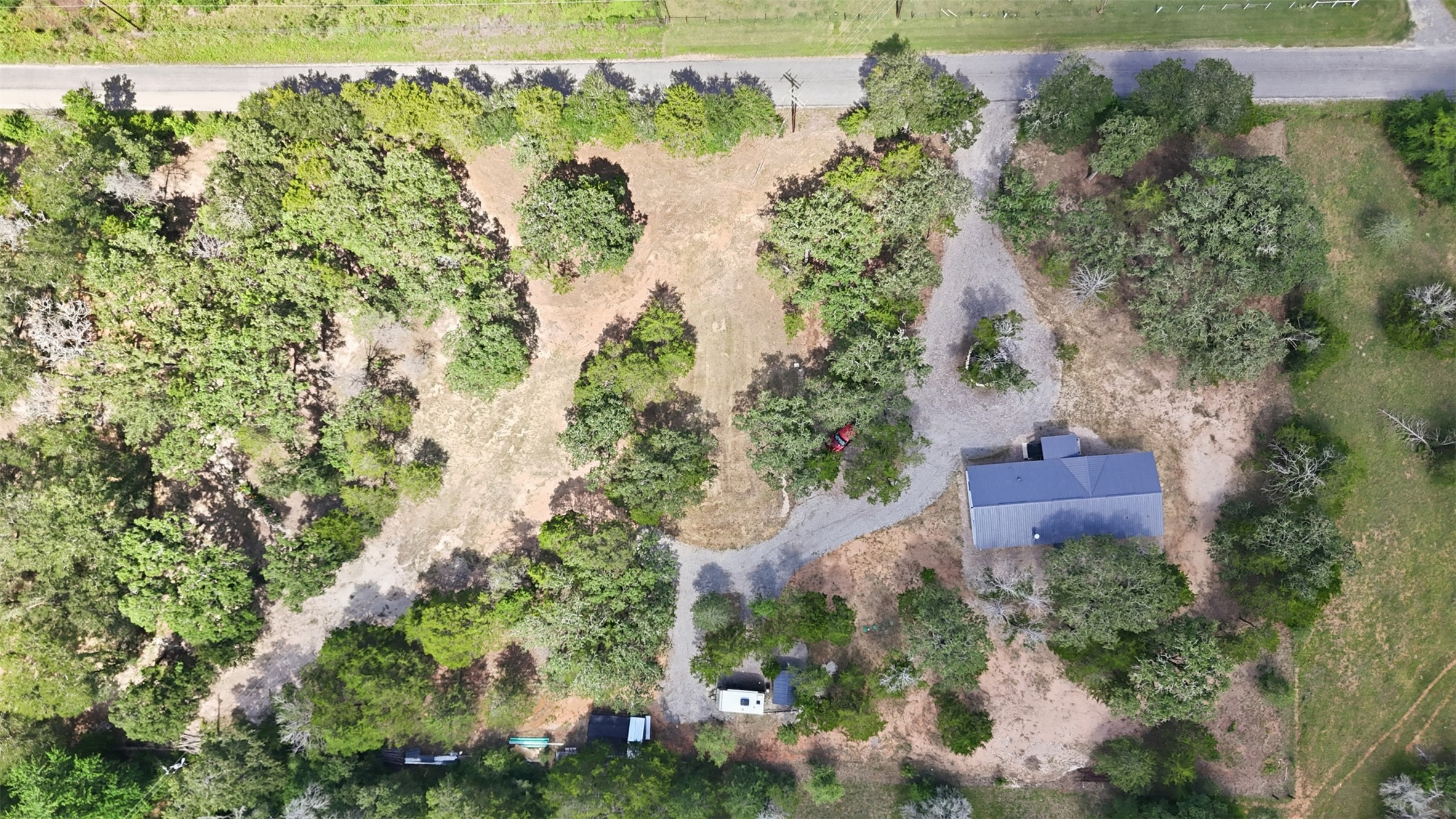 154 Antioch Road Smithville, TX 78957 - Photo 32 of 32 An aerial perspective reveals a secluded home nestled among mature trees, featuring ample privacy and natural surroundings.