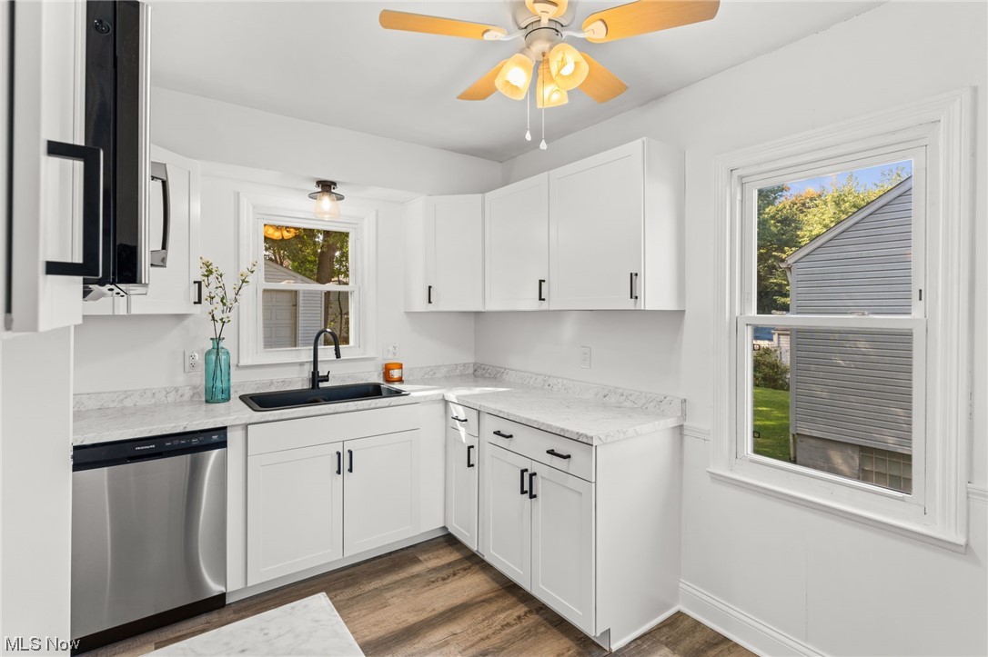 898 Reed Avenue Akron, OH 44306 - Photo 15 of 26 Kitchen featuring stainless steel dishwasher, white cabinets, light countertops, light hardwood flooring, and ceiling fan