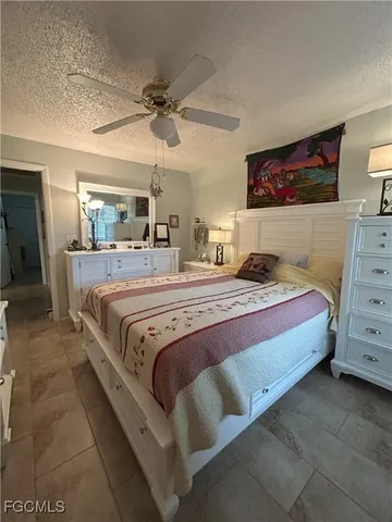 a spacious bedroom with a bed and a flat screen tv