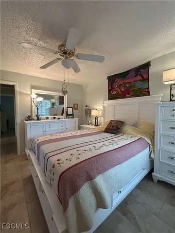 a bedroom with a bed and a flat tv screen on dresser