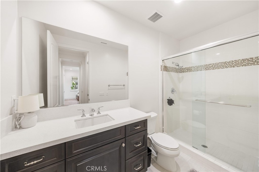 92 Interstellar Irvine, CA 92618 - Photo 15 of 64 a bathroom with a double vanity sink toilet mirror and shower