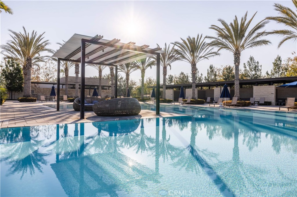 92 Interstellar Irvine, CA 92618 - Photo 51 of 64 a view of a swimming pool with a table and chairs under an umbrella