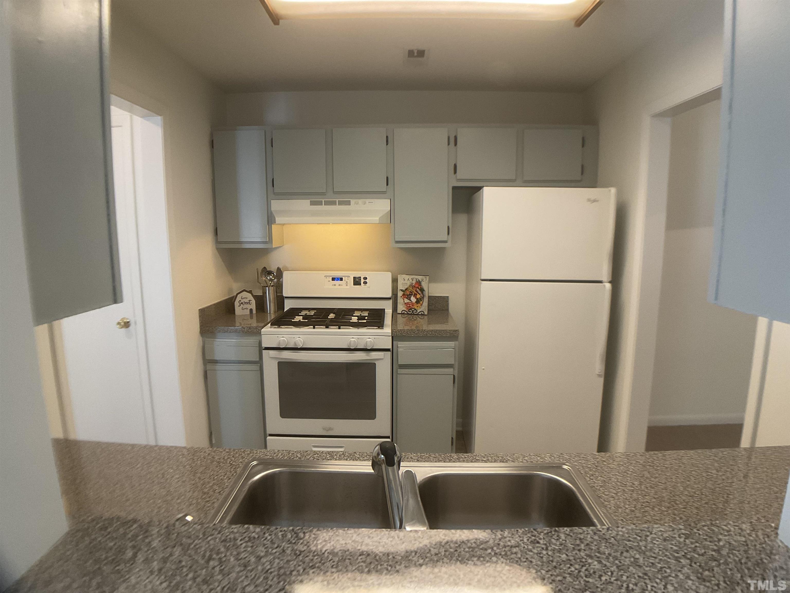 5812 Pointer Drive, Unit 202 Raleigh, NC 27609 - Photo 3 of 19 a kitchen with a sink a refrigerator and a stove top oven