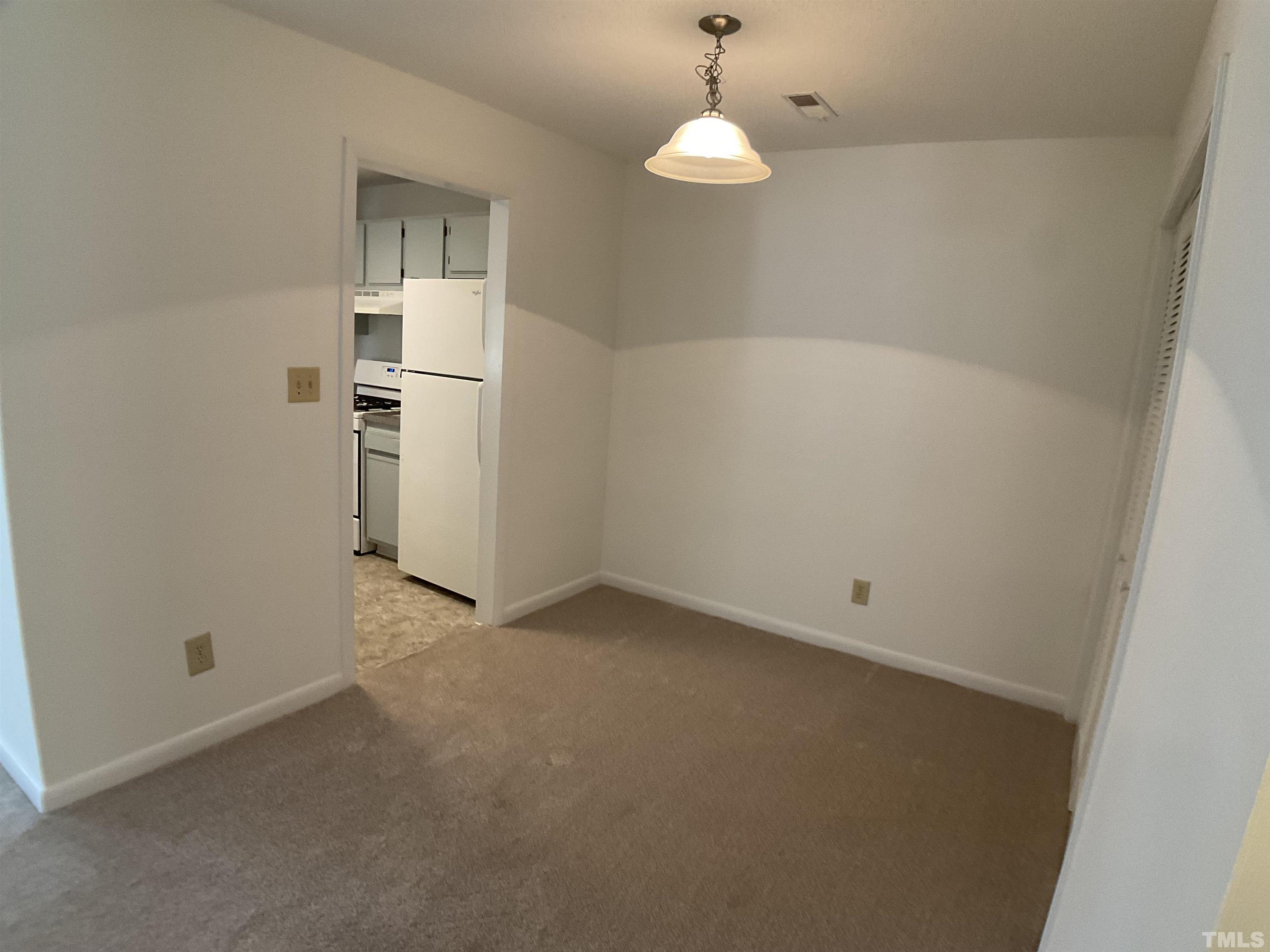5812 Pointer Drive, Unit 202 Raleigh, NC 27609 - Photo 6 of 19 an empty room with a empty space and chandelier fan