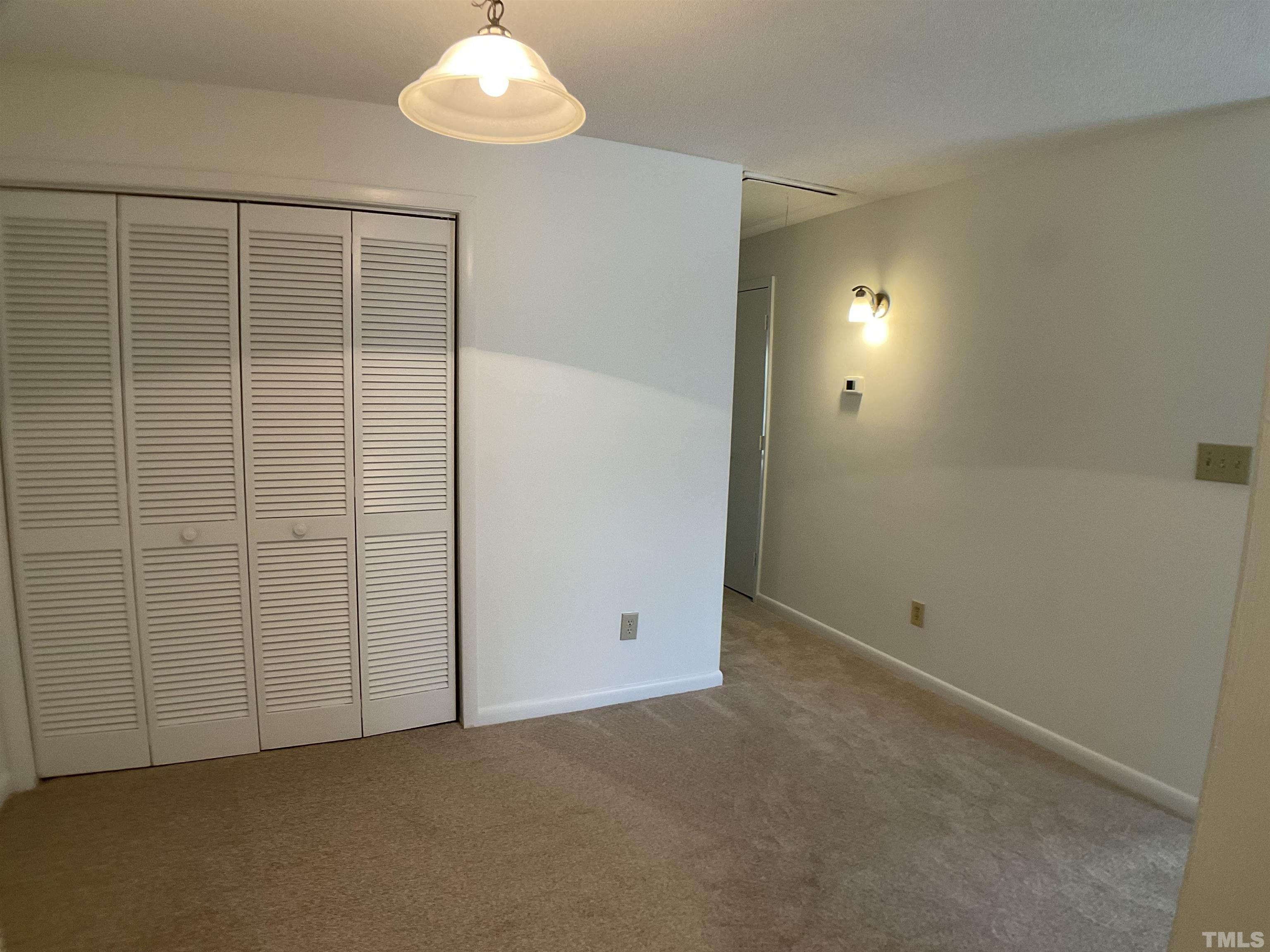 5812 Pointer Drive, Unit 202 Raleigh, NC 27609 - Photo 8 of 19 an empty room with chandelier fan