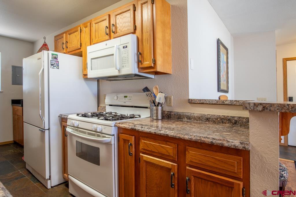 128 Hermosa Circle Durango, CO 81301 - Photo 12 of 26 a kitchen with stainless steel appliances granite countertop a sink stove and refrigerator