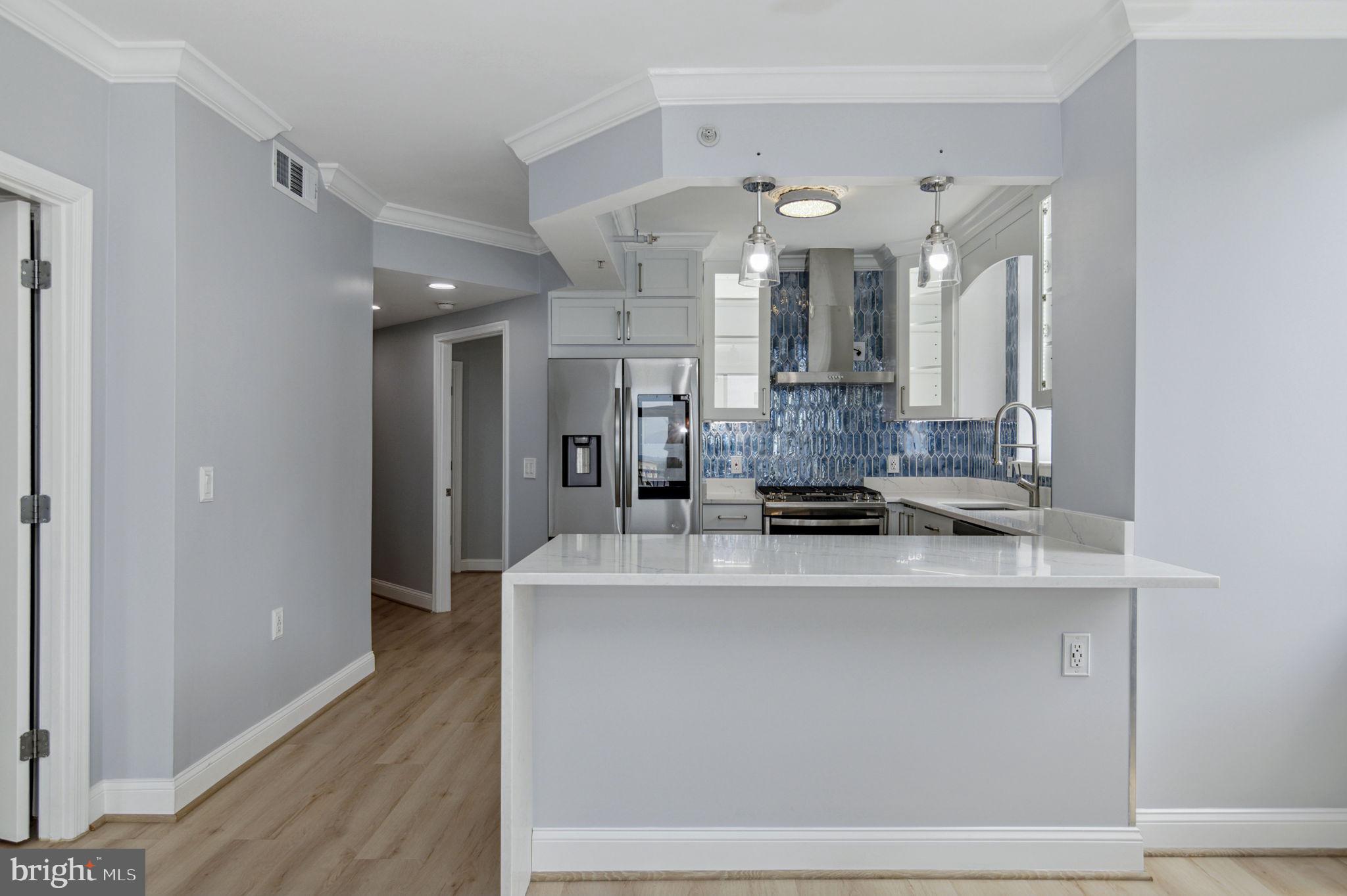851 North Glebe Road, Unit 1404 Arlington, VA 22203 - Photo 3 of 62 a large white kitchen with kitchen island and stainless steel appliances