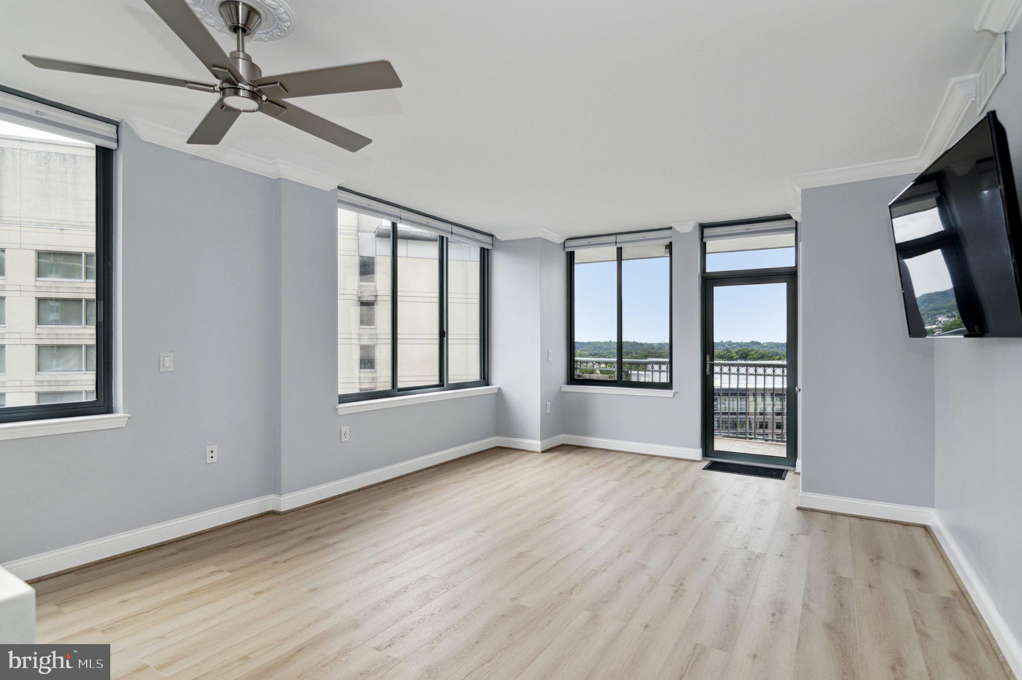 851 North Glebe Road, Unit 1404 Arlington, VA 22203 - Photo 10 of 62 a view of an empty room with a window and wooden floor