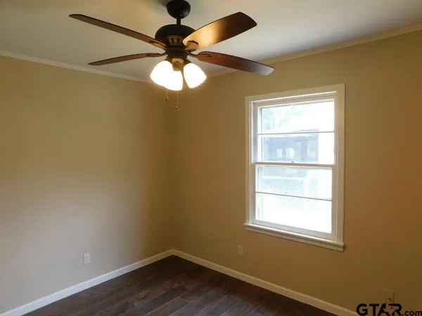 an empty room with a window and a fan